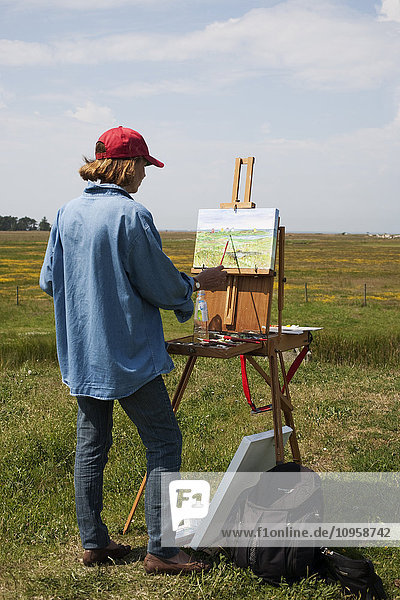 Woman painting outdoors Sweden.