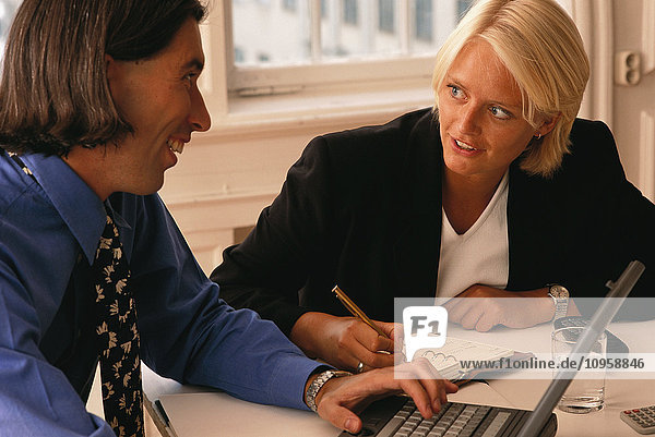 Ein Mann und eine Frau  die mit dem Computer diskutieren.