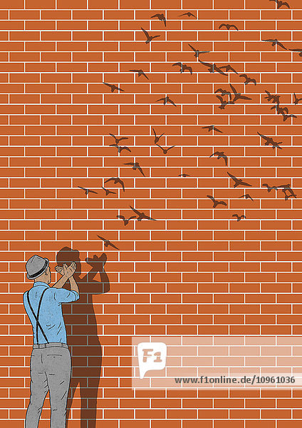Mann macht Handschatten an einer Wand mit fliegenden Vögeln