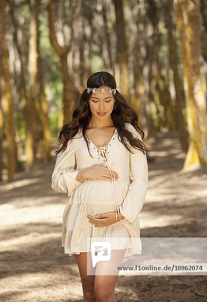 Eine schwangere Frau geht im Wald spazieren; Hawaii  Vereinigte Staaten von Amerika'.