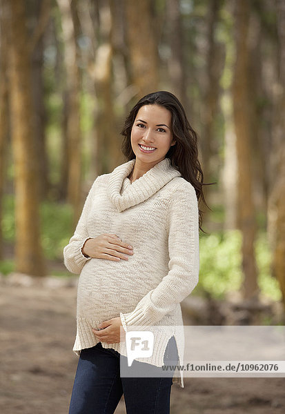 Eine schwangere Frau geht im Wald spazieren; Hawaii  Vereinigte Staaten von Amerika'.