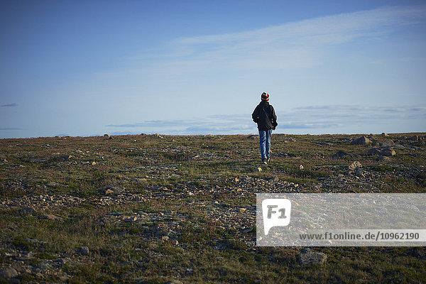 'Young boy walking on the tundra  near Cambridge Bay; Nunavut  Canada'