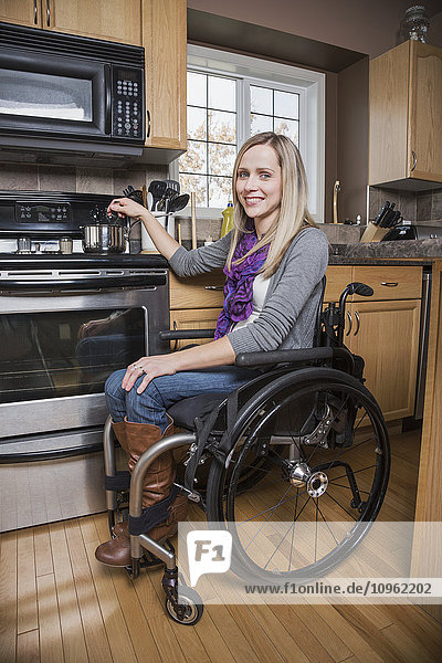 'Young disabled woman cooking in her kitchen; Spruce Grove  Alberta  Canada'