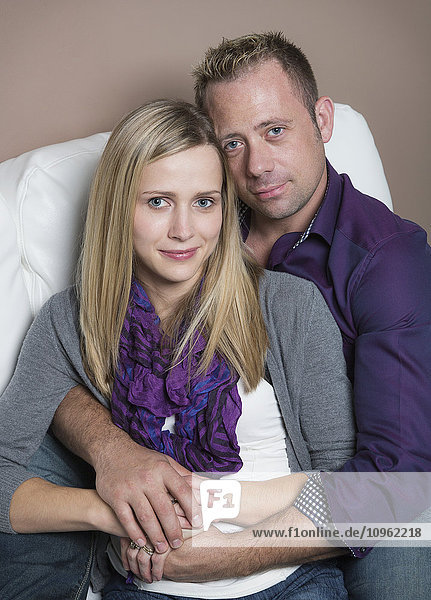 'Married couple cuddling on the couch  wife has a spinal cord injury and is a paraplegic; Spruce Grove  Alberta  Canada'