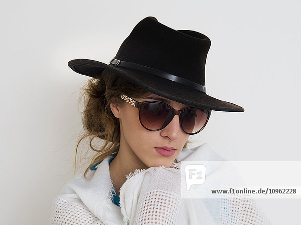 'Portrait of a girl wearing a black hat and sunglasses; England'