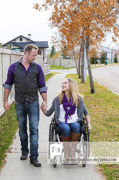 'Husband and wife with disability spending time together outdoors; Spruce Grove  Alberta  Canada'