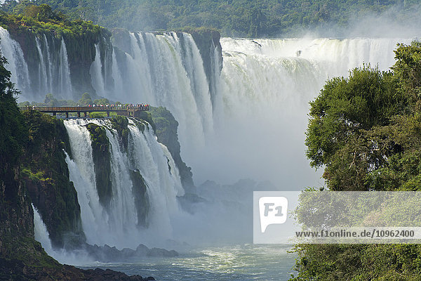Iguazu-Wasserfälle mit Touristen auf einem Steg; Argentinien'.