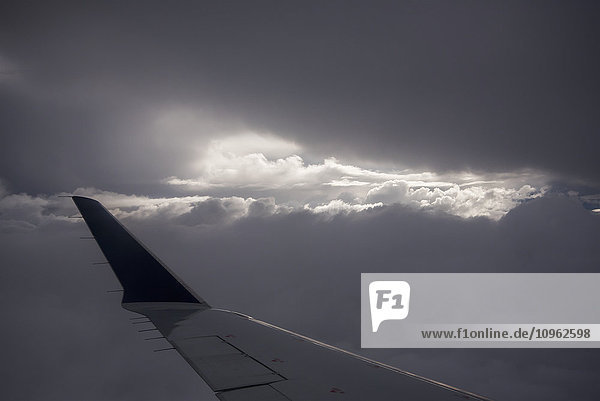 Flügel eines Flugzeugs mit Sonnenlicht  das durch Gewitterwolken scheint; Astoria  Oregon  Vereinigte Staaten von Amerika'.