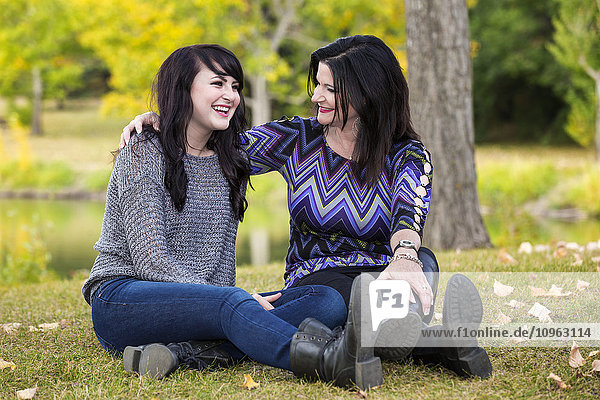 'Mother and daughter spending quality time together outdoors in a city park in autumn; St. Albert  Alberta  Canada'