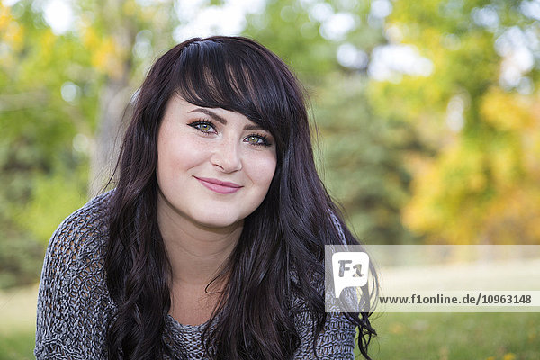 'Portrait of a beautiful young woman outdoors in a city park in autumn; St. Albert  Alberta  Canada'