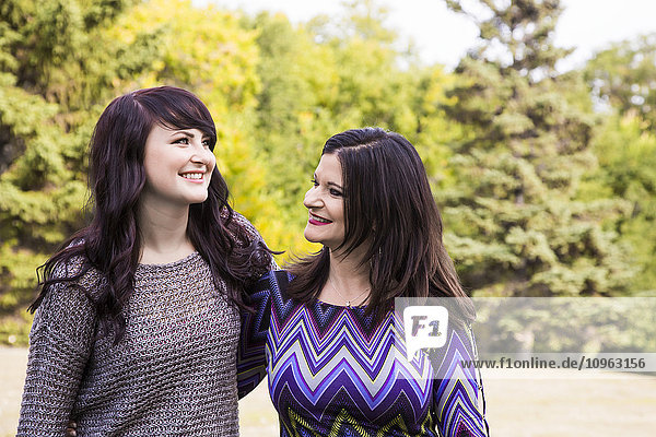 'Mother and daughter spending quality time together outdoors in a park in autumn; St. Albert  Alberta  Canada'