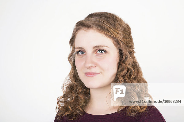 'Portrait of a young woman with blond curly hair on a white background; Alberta  Canada'