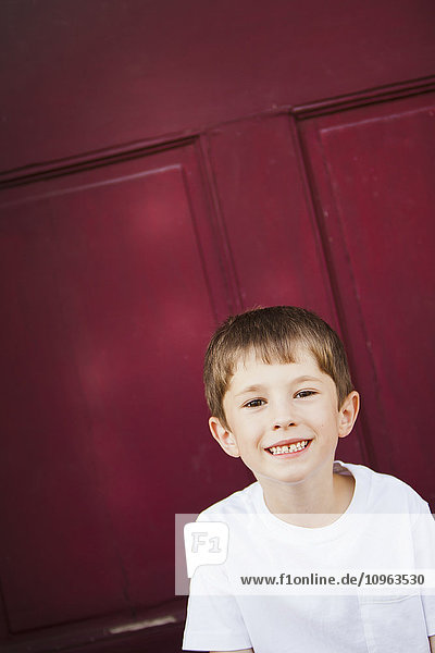 Porträt eines kleinen Jungen vor einer roten Tür; Nashville  Tennessee  Vereinigte Staaten von Amerika