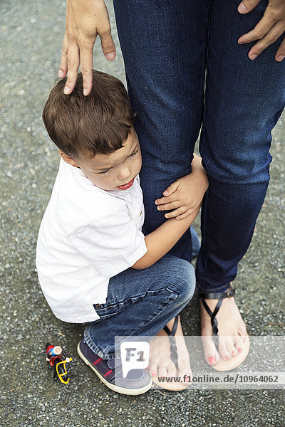 'A young son holding on to his mother's leg; Chilliwack  British Columbia  Canada'