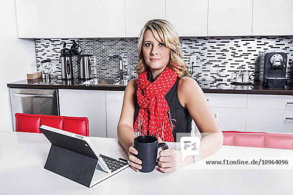 Geschäftsfrau  die eine Kaffeepause macht und ihr Tablet überprüft; St. Albert  Alberta  Kanada'.