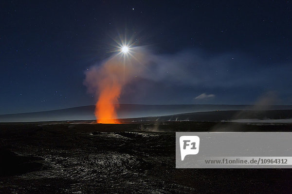 Vollmond über dem Halemaumau-Krater in der viel größeren Gipfelcaldera des Kilauea im Hawaii Volcanoes National Park, dampfende Schlote im Vordergrund, der Berg Mauna Loa im Hintergrund; Insel Hawaii, Hawaii, Vereinigte Staaten von Amerika'.