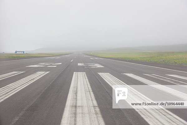 View down the runway of the St. Paul airport on a misty afternoon  St. Paul Island  Southwestern Alaska  USA  Summer