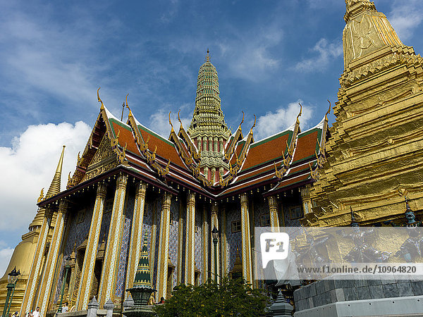 'Ornate building and gold structures with statues  Temple of the Emerald Buddha (Wat Phra Kaew); Bangkok  Thailand'