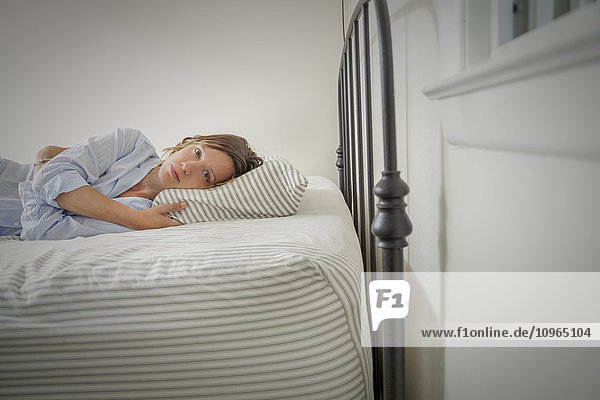 Young woman lying on her bed