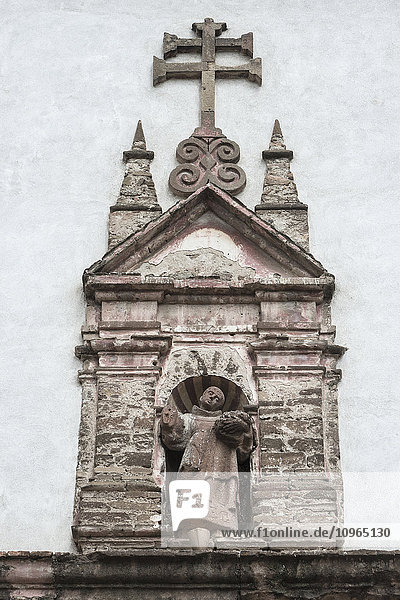 'Stone sculpture of a man standing in a doorway of a building; San Miguel de Allende  Guanajuato  Mexico'