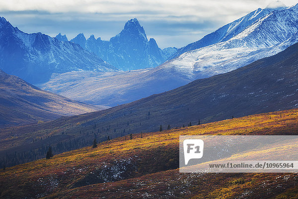 'The north Klondike valley lights up along the Dempster Highway with Tombstone mountain in the distance; Yukon Canada'