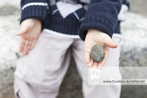 Junge hält einen Stein in der Hand  Bear Creek Park; Surrey  British Columbia  Kanada'.