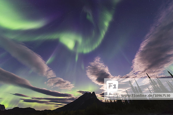 Das Polarlicht und die Wolken teilen sich den Himmel über dem Berg Sukakpak in der Brooks Range nördlich von Wiseman  Arctic Alaska.