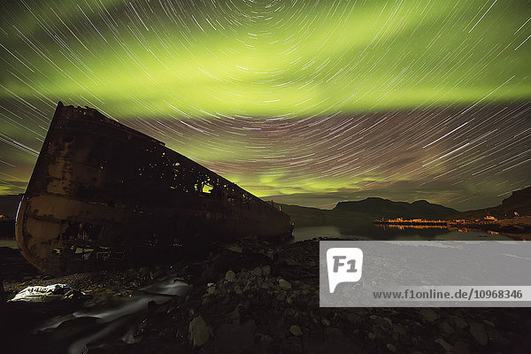 'Star trails and northern lights over top the town of Djupavik in the West Fjords of Iceland; Djupavik Iceland'