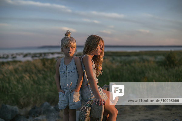 'Sisters together on the beach at sunset; Surrey  British Columbia  Canada'