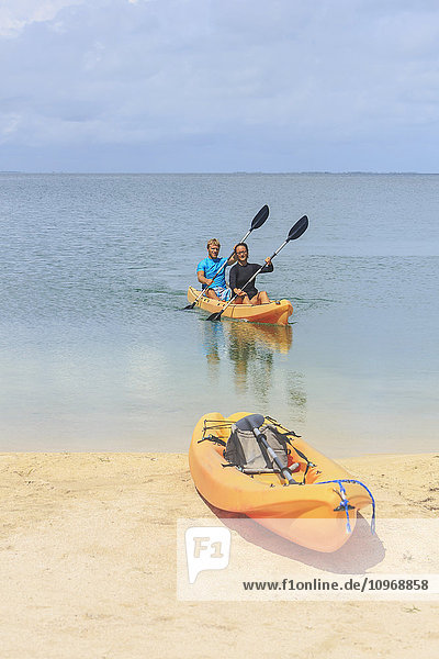 Ein Paar  das in einem Kajak am Strand ankommt  Saint Georges Caye Resort; Belize City  Belize'.