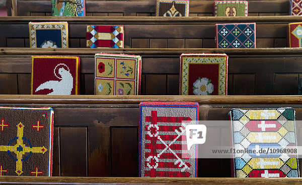 Bunte  gemusterte Kissen auf Holzbänken in einer Kirche; Yorkshire Dales  England