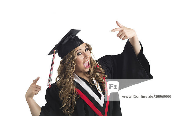 'Young female graduate pointing at her grad cap in celebration; Edmonton  Alberta  Canada'
