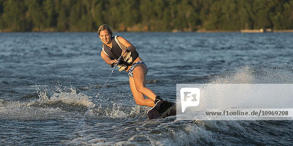 Eine junge Frau beim Wakeboarden auf einem See; Ontario  Kanada