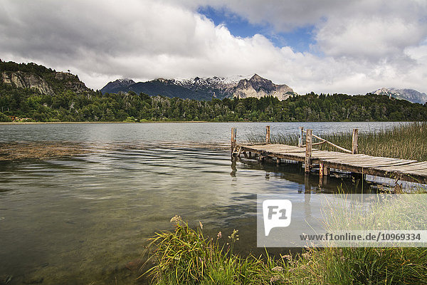 Ein hölzerner Steg führt den Blick auf einen kleinen Bergsee; Bariloche  Argentinien'.