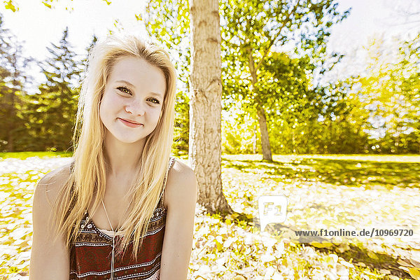 Porträt einer schönen jungen Frau mit langem  blondem Haar in einem Stadtpark im Herbst; Edmonton  Alberta  Kanada'.