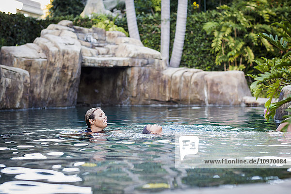 Eine Familie genießt einen Nachmittag im Pool an einem sonnigen Nachmittag; Fountain Valley  Kalifornien  Vereinigte Staaten von Amerika'.