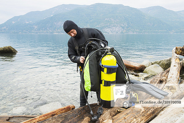 Ein Taucher bereitet seine Ausrüstung vor einem Tauchgang vor  Britannia Beach; Howe Sound  British Columbia  Kanada'.