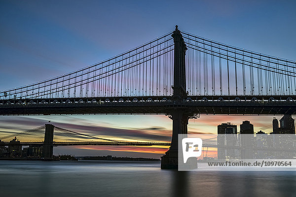 Sonnenuntergang hinter der Manhattan- und der Brooklyn-Brücke; New York City  New York  Vereinigte Staaten von Amerika'.