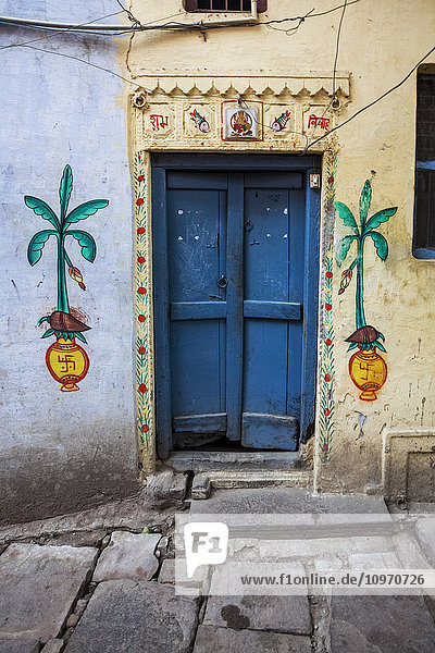 Eine Tür zu einem Haus  bemalt mit lokalen Hindu-Motiven  einschließlich hinduistischer Hakenkreuze; Varanasi  Indien'.