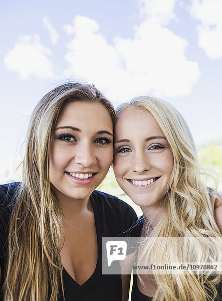 Zwei Freundinnen posieren für die Kamera in einem Stadtpark in der Innenstadt; Edmonton  Alberta  Kanada'.