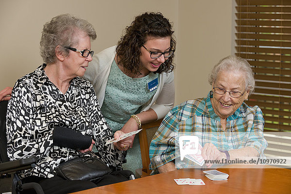 Senioren und Betreuerin spielen Karten in ihrer gemeinsamen Wohnung; Edmonton  Alberta  Kanada