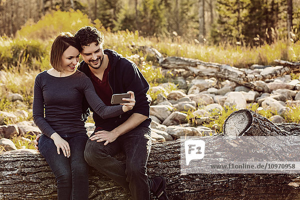 Ein junges Paar macht ein Selbstporträt bei einem Herbstspaziergang in einem Stadtpark; Edmonton  Alberta  Kanada'.