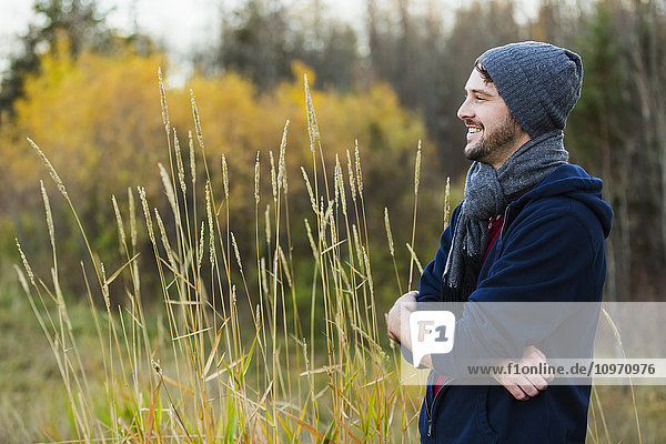 Ein gut aussehender junger erwachsener Mann genießt einen Herbstausflug im Park; Edmonton  Alberta  Kanada'.