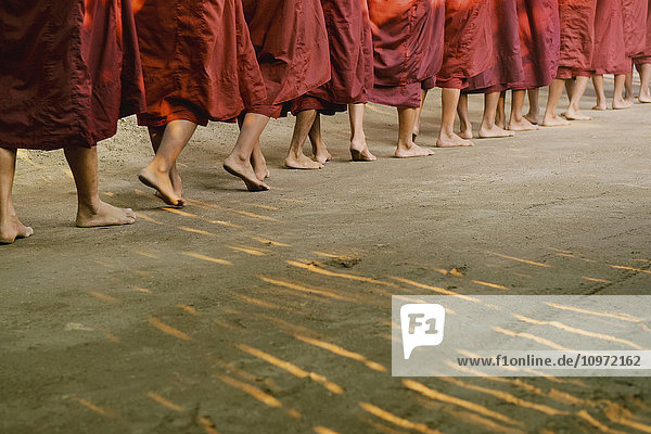 'Buddhist monks walking in a row in bare feet; Bagan  Myanmar'