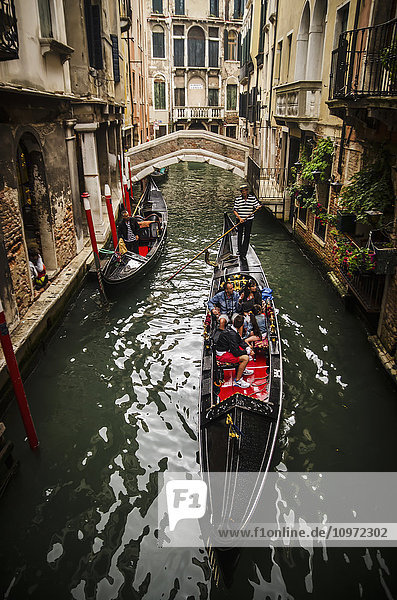 Touristen  die durch die engen Kanäle von Venedig staken; Venedig  Italien'.
