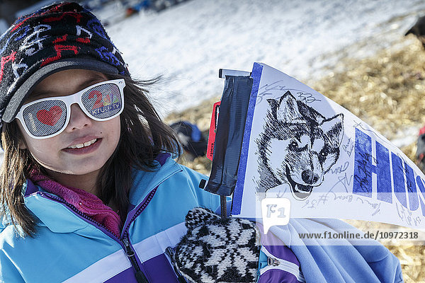 A young Huslia race fan shows her spirit in the afternoon at the Huslia checkpoint during Iditarod 2015