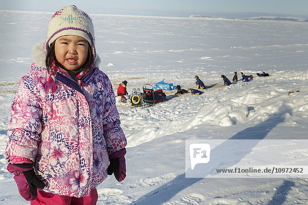 Young native Alaskan girl watches the teams rest at the Shaktoolik checkpoint during Iditarod 2015