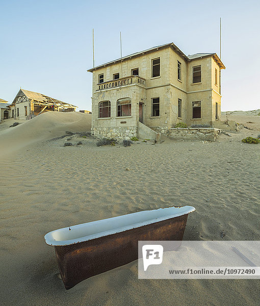'An old bathtub lying in the sand outside abandoned houses; Kolmanskop  Namibia'