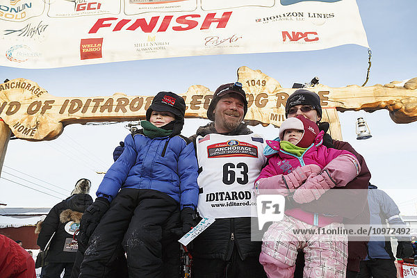 Aaron Burmeister poses with his family shortly after finishing in third place at in Nome during Iditarod 2015