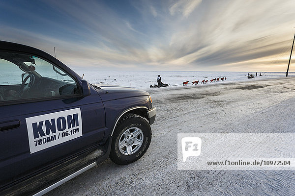 Ken Anderson auf dem Trail einige Meilen vor der Ziellinie in Nome überholt den KNOM-Radio-Spotter während des Iditarod 2015